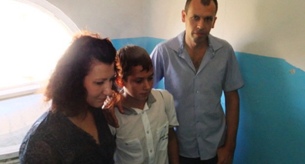  

Elena, Konstantin and Maxim Shablo waiting for court marshals in the doorway of No. 20 Yasnogorskaya Street, Sochi, September 26, 2012. Photo by Svetlana Kravchenko for the "Caucasian Knot"

 