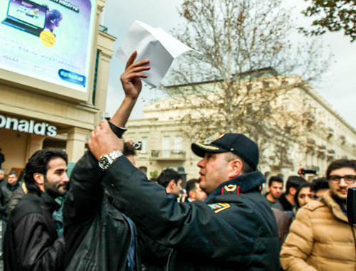 Baku, The Fountain Square, December 8, 2013. The policeman trying to prevent a silent protest against rise in fuel prices. Photo by Aziz Karimov for the ‘Caucasian Knot’. Baku, The Fountain Square, December 8, 2013. The policeman trying to prevent a silent protest against rise in fuel prices. Photo by Aziz Karimov for the ‘Caucasian Knot’.