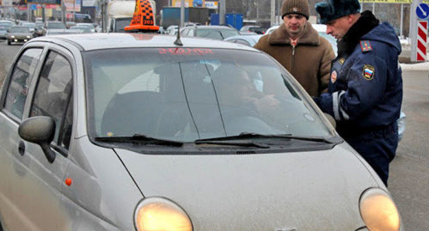 Ф policeman of the separate battalion of the road-and-patrol service checks the documents of a taxi driver on the streets of Stavropol. Photo: http://fedpress.ru/ Ф policeman of the separate battalion of the road-and-patrol service checks the documents of a taxi driver on the streets of Stavropol. Photo: http://fedpress.ru/