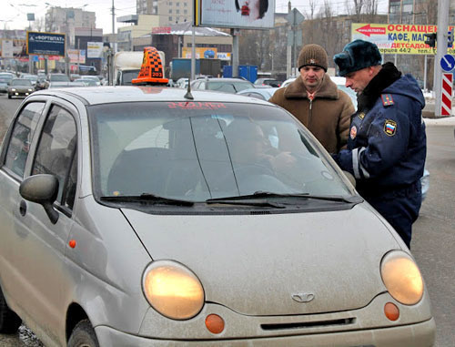 Ф policeman of the separate battalion of the road-and-patrol service checks the documents of a taxi driver on the streets of Stavropol. Photo: http://fedpress.ru/ Ф policeman of the separate battalion of the road-and-patrol service checks the documents of a taxi driver on the streets of Stavropol. Photo: http://fedpress.ru/