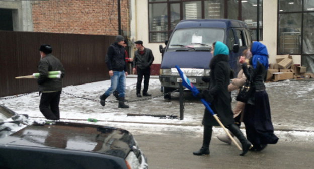 Grozny residents go away with folded flags after the celebrations on the arrival of the Olympic Torch Relay. January 28, 2014. Photo by the "Caucasian Knot" Grozny residents go away with folded flags after the celebrations on the arrival of the Olympic Torch Relay. January 28, 2014. Photo by the "Caucasian Knot"