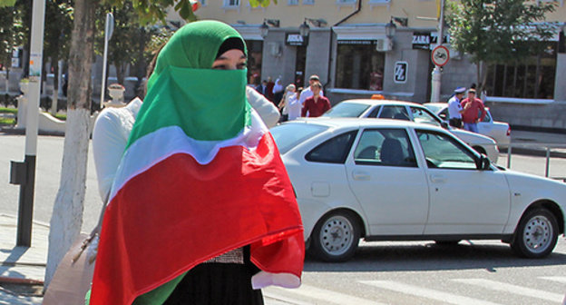 Woman covered her face with Chechen flag during celebrations of the Republic’s Day. Grozny, September 2014. Photo by Magomed Magomedov for the ‘Caucasian Knot’. Woman covered her face with Chechen flag during celebrations of the Republic’s Day. Grozny, September 2014. Photo by Magomed Magomedov for the ‘Caucasian Knot’.