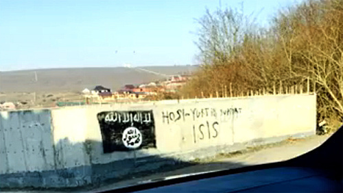 An image of the flag used by the militants of the "Islamic State" (recognized on December 29, 2014, by the Supreme Court of the Russian Federation as a terrorist organization) on a wall of the building in the village of Khosi-Yurt. Photo: screenshot of a video ISIS in Khosi-Yurt / IG in Chechnya, http://www.youtube.com/watch?v=n2sVCqLfPp0 An image of the flag used by the militants of the "Islamic State" (recognized on December 29, 2014, by the Supreme Court of the Russian Federation as a terrorist organization) on a wall of the building in the village of Khosi-Yurt. Photo: screenshot of a video ISIS in Khosi-Yurt / IG in Chechnya, http://www.youtube.com/watch?v=n2sVCqLfPp0