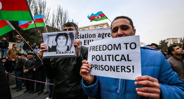A participant of the protest action holds a poster with a portrait of a political prisoner Khadija Ismayilova and a poster 'Freedom to political prisoners!'. Baku, March 15, 2015. Photo by Aziz Karimov for the "Caucasian Knot"