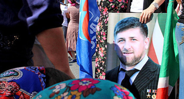 The participant of the action celebrating the day of the republic in Chechnya holds Ramzan Kadyrov's portrait. Grozny, September 6, 2014. Photo by Magomed Magomedov for the "Caucasian Knot' The participant of the action celebrating the day of the republic in Chechnya holds Ramzan Kadyrov's portrait. Grozny, September 6, 2014. Photo by Magomed Magomedov for the "Caucasian Knot'