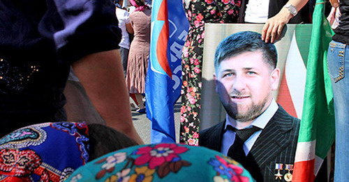 The participant of the action celebrating the day of the republic in Chechnya holds Ramzan Kadyrov's portrait. Grozny, September 6, 2014. Photo by Magomed Magomedov for the "Caucasian Knot' The participant of the action celebrating the day of the republic in Chechnya holds Ramzan Kadyrov's portrait. Grozny, September 6, 2014. Photo by Magomed Magomedov for the "Caucasian Knot'