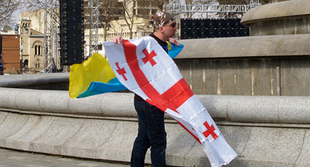 The participant of the "United National Movement" rally holds the flags of Georgia and Ukraine. Tbilisi, March 2015. Photo by Beslan Kmuzov for the "Caucasian Knot" The participant of the "United National Movement" rally holds the flags of Georgia and Ukraine. Tbilisi, March 2015. Photo by Beslan Kmuzov for the "Caucasian Knot"