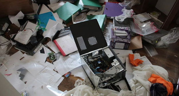 Broken personal computer lying on the heap of papers Broken personal computer lying on the heap of papers
