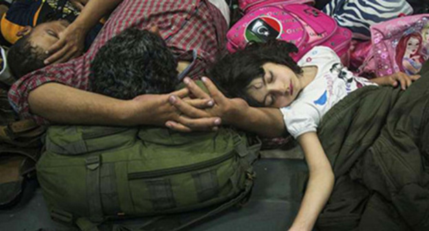 An exhausted Syrian girl is asleep next her father after they have been saved by the Italian ship. Photo: @UNHCR/A.D’Amato, http://www.unhcr.ru/ An exhausted Syrian girl is asleep next her father after they have been saved by the Italian ship. Photo: @UNHCR/A.D’Amato, http://www.unhcr.ru/