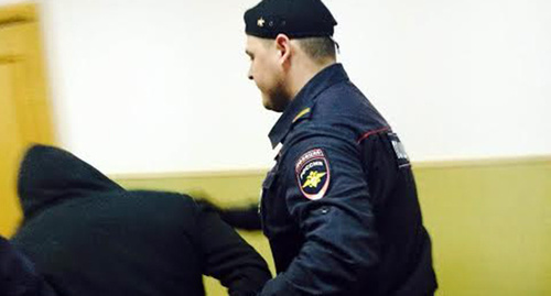 Police officer escorts defendant to the court room. Photo by Yulia Buslavskaya for the ‘Caucasian Knot’. Police officer escorts defendant to the court room. Photo by Yulia Buslavskaya for the ‘Caucasian Knot’.