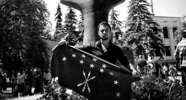 Nartan Kylych holding the Circassian flag in front of a monument to victims of the Caucasian War in Nalchik. Photo: Aslan Schakue, Fatima Tlisova and Olga Efendieva-Begret, https://www.facebook.com/photo.php?fbid=10153411014089002&set=a.10150641558564002.436428.531449001&type=1&fref=nf&pnref=story
