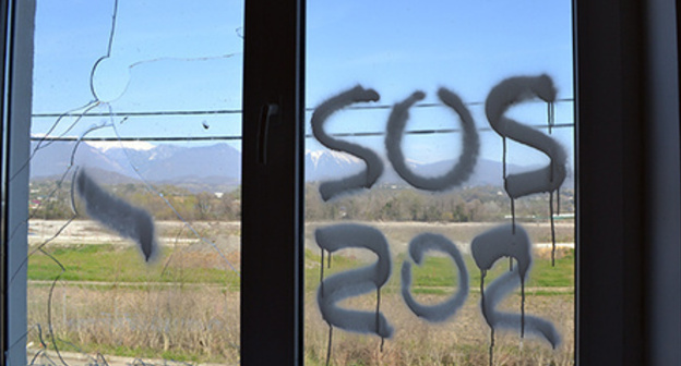 Inscription 'SOS' on the window of dilapidated house of cottage settlement for Olympic resettlers, Vesyoloe-Psou neighbourhood, Adler District of Sochi. Photo by Svetlana Kravchenko for the ‘Caucasian Knot’. Inscription 'SOS' on the window of dilapidated house of cottage settlement for Olympic resettlers, Vesyoloe-Psou neighbourhood, Adler District of Sochi. Photo by Svetlana Kravchenko for the ‘Caucasian Knot’.