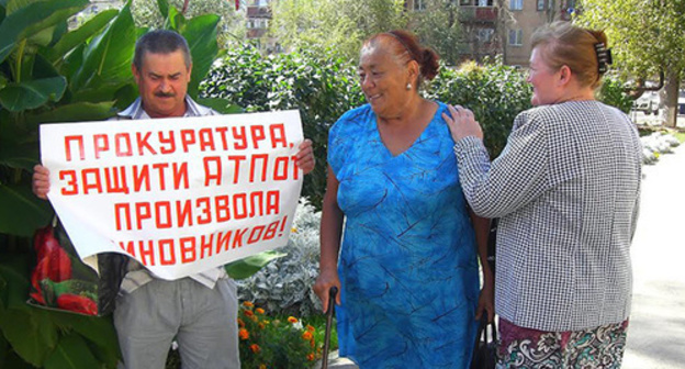The participant of a solo picket holds a poster in support of the MP "Akhtuba ATP" employees. Akhtubinsk, September 21, 2015. Photo by Yelena Grebenyuk for the "Caucasian Knot" The participant of a solo picket holds a poster in support of the MP "Akhtuba ATP" employees. Akhtubinsk, September 21, 2015. Photo by Yelena Grebenyuk for the "Caucasian Knot"