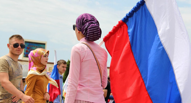 A woman with a Russian flag in her hands. Photo by Magomed Magomedov for the "Caucasian Knot" A woman with a Russian flag in her hands. Photo by Magomed Magomedov for the "Caucasian Knot"