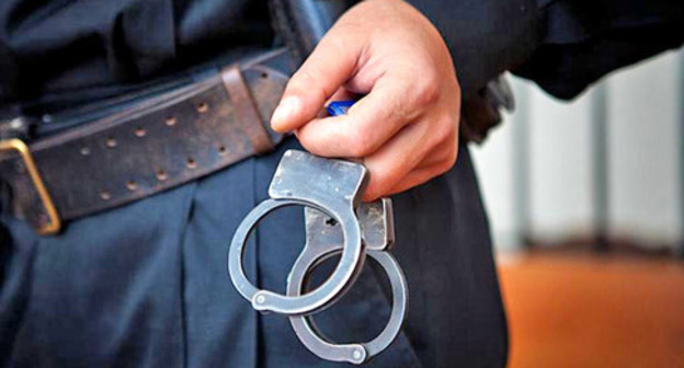 Law enforcer with handcuffs. Photo: Fedor Obmaikin / Yugopolis Law enforcer with handcuffs. Photo: Fedor Obmaikin / Yugopolis