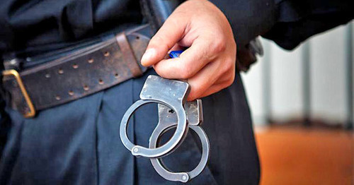 Law enforcer with handcuffs. Photo: Fedor Obmaikin / Yugopolis Law enforcer with handcuffs. Photo: Fedor Obmaikin / Yugopolis