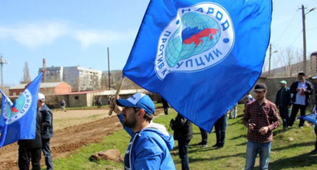 Activist of the "People Against Corruption" party holding flag. Photo: http://www.dagestanpost.ru/novosti/vrepublice/30593-aktivisty-iniciativnoj-gruppy-narod-protiv-korrupcii-vyshli-na-stroitelstvo-narodnogo-stadiona-v-maxachkale Activist of the "People Against Corruption" party holding flag. Photo: http://www.dagestanpost.ru/novosti/vrepublice/30593-aktivisty-iniciativnoj-gruppy-narod-protiv-korrupcii-vyshli-na-stroitelstvo-narodnogo-stadiona-v-maxachkale