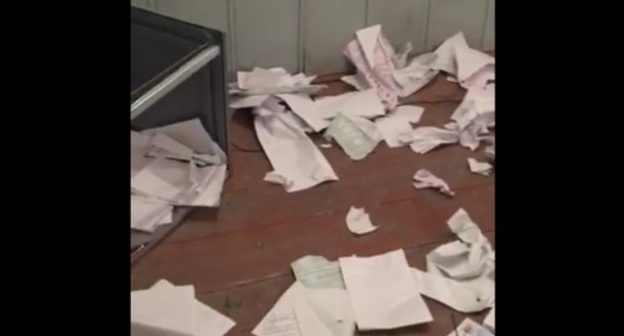 A broken ballot box and torn and trampled down ballot papers at the polling station in the village of Gotsatl. Screenshot of a video from the "Dagestan Online" community on Facebook, facebook.com/groups/dagonline A broken ballot box and torn and trampled down ballot papers at the polling station in the village of Gotsatl. Screenshot of a video from the "Dagestan Online" community on Facebook, facebook.com/groups/dagonline