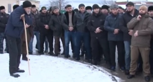 Aslanbek Bakharchiev stands in the circle (with a crutch) during gathering of local residents of the village of Prigorodnoye, December 21, 2016. Screenshot: https://www.youtube.com/watch?v=5Def1pvJo6U Aslanbek Bakharchiev stands in the circle (with a crutch) during gathering of local residents of the village of Prigorodnoye, December 21, 2016. Screenshot: https://www.youtube.com/watch?v=5Def1pvJo6U