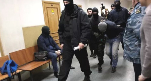 Shagid Gubashev, a defendant in the Boris Nemtsov's murder case, is convoyed through the corridor of the Basmanny Court of Moscow. Photo: Centre for Investigative Journalism http://investigator.org.ua/news/150556/