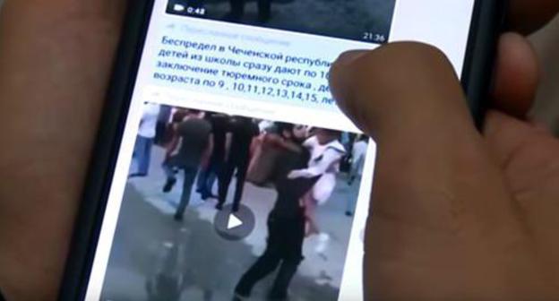 Playing video on a smartphone where convicts' relatives express their indignation at the verdicts. Screenshot from video broadcasted by "Grozny" TV Channel: https://www.youtube.com/watch?v=ljPg7TqLENs Playing video on a smartphone where convicts' relatives express their indignation at the verdicts. Screenshot from video broadcasted by "Grozny" TV Channel: https://www.youtube.com/watch?v=ljPg7TqLENs