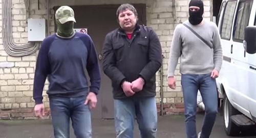 Khazvakha Cherkhigov (centre) is detained by law enforcers. Screenshot from FSB video Khazvakha Cherkhigov (centre) is detained by law enforcers. Screenshot from FSB video