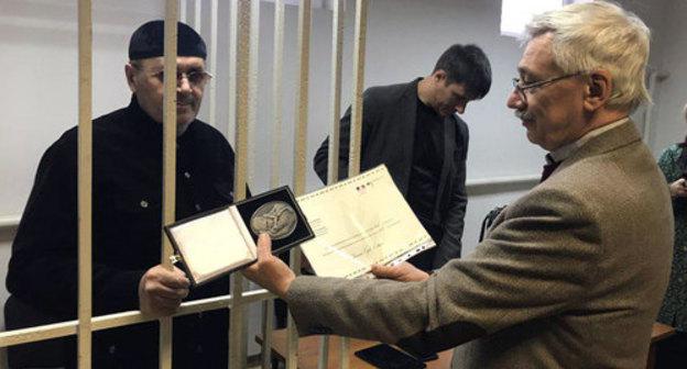 Oleg Orlov shows the Franco-German Prize "For Human Rights and Rule of Law" awarded to Oyub Titiev. Photo by Patimat Makhmudova for the Caucasian Knot Oleg Orlov shows the Franco-German Prize "For Human Rights and Rule of Law" awarded to Oyub Titiev. Photo by Patimat Makhmudova for the Caucasian Knot