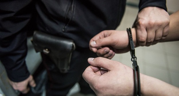 Policeman placing suspect in handcuffs. Photo: Elena Sineok / Yuga.ru Policeman placing suspect in handcuffs. Photo: Elena Sineok / Yuga.ru