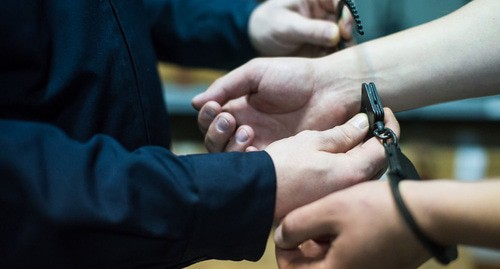 A law enforcer handcuffs a detainee. Photo by Yelena Sineok, Yuga.ru A law enforcer handcuffs a detainee. Photo by Yelena Sineok, Yuga.ru