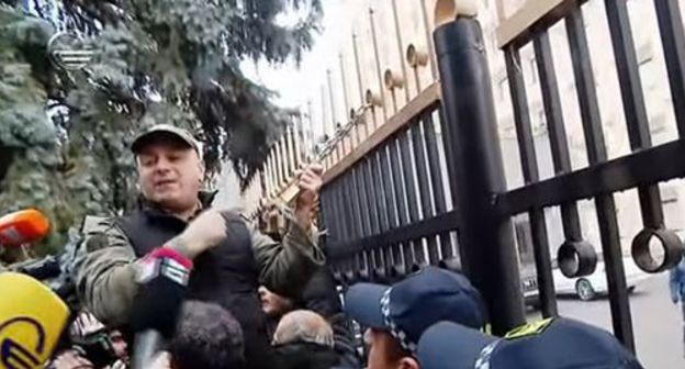 Opposition supporters hung a symbolic lock on the fence of the government building. Screenshot from Youtube video posted by "TV IMEDI" https://www.youtube.com/watch?v=dgm7LXcNjn0 Opposition supporters hung a symbolic lock on the fence of the government building. Screenshot from Youtube video posted by "TV IMEDI" https://www.youtube.com/watch?v=dgm7LXcNjn0