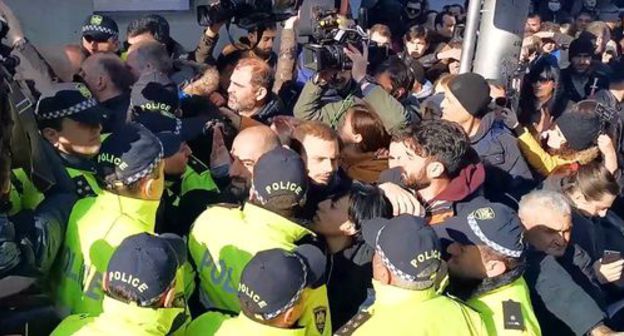 Activists and police officers in front of the National Library near the Georgian parliament building on November 29, 2019. Screenshot of the video by Sputnik Georgia https://sputnik-georgia.ru/video/20191129/247144476/Oppozitsiya-v-ocherednoy-raz-popytalas-pomeshat-rabote-parlamenta-Gruzii-video.html Activists and police officers in front of the National Library near the Georgian parliament building on November 29, 2019. Screenshot of the video by Sputnik Georgia https://sputnik-georgia.ru/video/20191129/247144476/Oppozitsiya-v-ocherednoy-raz-popytalas-pomeshat-rabote-parlamenta-Gruzii-video.html