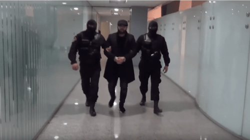 Two masked law enforcers are escorting handcuffed Narek Sargsyan at Zvartnots Airport in Yerevan. Screenshot from video posted at: https://www.youtube.com/watch?time_continue=16&v=1MUWqxKFicE&feature=emb_title Two masked law enforcers are escorting handcuffed Narek Sargsyan at Zvartnots Airport in Yerevan. Screenshot from video posted at: https://www.youtube.com/watch?time_continue=16&v=1MUWqxKFicE&feature=emb_title