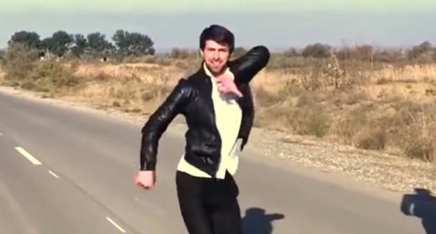 A young man dancing lezginka on the road. Screenshot from Murad Khatiev's video: https://www.youtube.com/watch?v=HNzJpO0Kk60 A young man dancing lezginka on the road. Screenshot from Murad Khatiev's video: https://www.youtube.com/watch?v=HNzJpO0Kk60