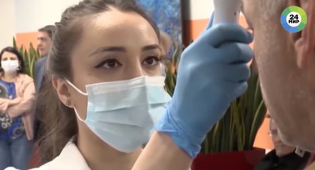 Temperature screening of a hospital visitor. Screenshot of the video at the «Мир 24» YouTube channel https://www.youtube.com/watch?v=Xw6hNz5Jt74 Temperature screening of a hospital visitor. Screenshot of the video at the «Мир 24» YouTube channel https://www.youtube.com/watch?v=Xw6hNz5Jt74
