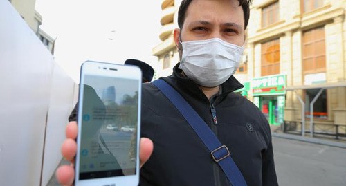 A resident of Baku shows an SMS permit for leaving home. Photo REUTERS/Aziz Karimov A resident of Baku shows an SMS permit for leaving home. Photo REUTERS/Aziz Karimov
