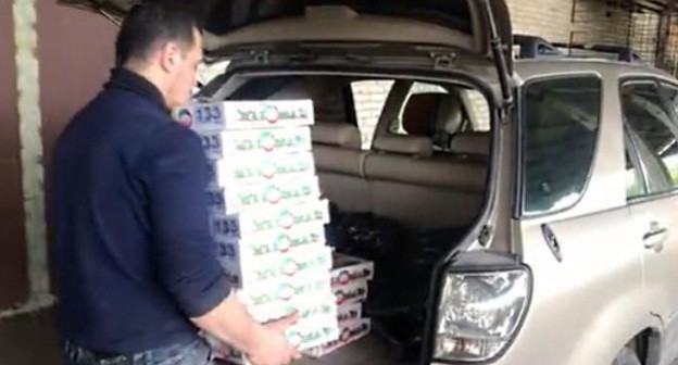 A volunteer loads foodstuff parcels for those in need in a car. Photo by Lyudmila Maratova for the "Caucasian Knot" A volunteer loads foodstuff parcels for those in need in a car. Photo by Lyudmila Maratova for the "Caucasian Knot"