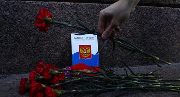A hand with flowers near the Constitution booklet. Photo: REUTERS/Anton Vaganov A hand with flowers near the Constitution booklet. Photo: REUTERS/Anton Vaganov