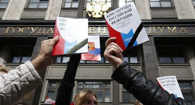 People holding the Constitution of Russia in front of the State Duma building. Photo: REUTERS/Sergei Karpukhin People holding the Constitution of Russia in front of the State Duma building. Photo: REUTERS/Sergei Karpukhin