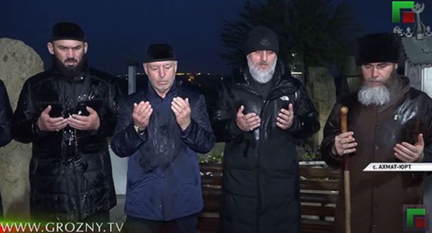 Chechen officials standing at the Akhmat Kadyrov' grave. Screenshot from video posted by ChGTRK 'Grozny': https://www.youtube.com/watch?v=rTNrwO_-jl4&feature=emb_title Chechen officials standing at the Akhmat Kadyrov' grave. Screenshot from video posted by ChGTRK 'Grozny': https://www.youtube.com/watch?v=rTNrwO_-jl4&feature=emb_title