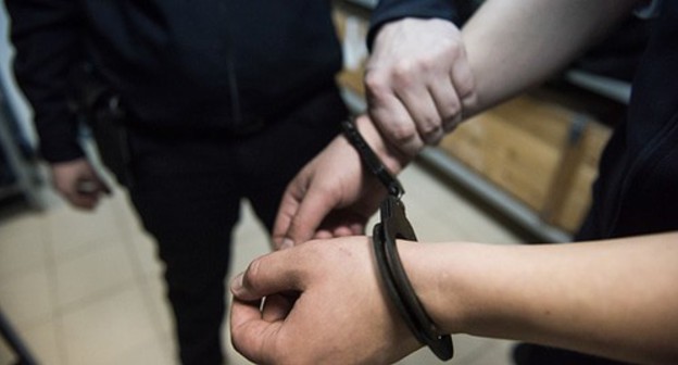 Policeman holding a detainee's hand. Photo: Elena Sineok, Yuga.ru Policeman holding a detainee's hand. Photo: Elena Sineok, Yuga.ru