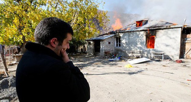 A resident of Nagorno-Karabakh near a burning house. November 2020. Photo: REUTERS/Stringer A resident of Nagorno-Karabakh near a burning house. November 2020. Photo: REUTERS/Stringer