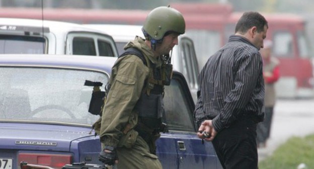 A law enforcer escorts an arrested man. Nalchik, October 14, 2005. Photo: REUTERS/Viktor Korotayev A law enforcer escorts an arrested man. Nalchik, October 14, 2005. Photo: REUTERS/Viktor Korotayev