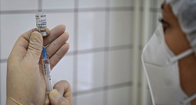 A medical worker holds a syringe and a vaccine. Photo: REUTERS / Sergey Pivovarov A medical worker holds a syringe and a vaccine. Photo: REUTERS / Sergey Pivovarov