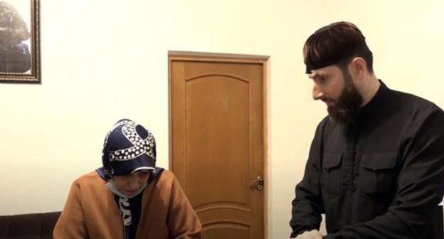 Zarema Makhmudova, a resident of the Gudermes District, and the theologian, Adam Elzhurkaev. Screenshot of the video by the "Grozny" TV Channel https://www.youtube.com/watch?v=DPch-luKpbk&feature=emb_logo Zarema Makhmudova, a resident of the Gudermes District, and the theologian, Adam Elzhurkaev. Screenshot of the video by the "Grozny" TV Channel https://www.youtube.com/watch?v=DPch-luKpbk&feature=emb_logo