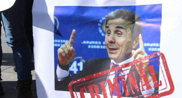 Poster held by a rally participant with a photo of Bidzina Ivanishvili, founder of the "Georgian Dream" Party, and inscription 'Criminal'. Photo by Inna Kukudzhanova for the Caucasian Knot Poster held by a rally participant with a photo of Bidzina Ivanishvili, founder of the "Georgian Dream" Party, and inscription 'Criminal'. Photo by Inna Kukudzhanova for the Caucasian Knot