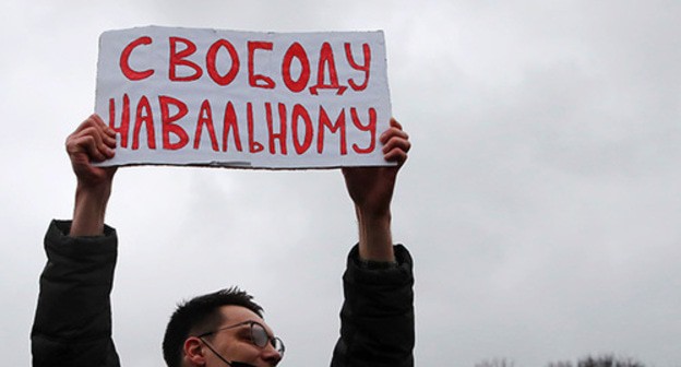 A protestor holding banner in support of Alexei Navalny. Abstract illustration. Photo: REUTERS/Anton Vaganov A protestor holding banner in support of Alexei Navalny. Abstract illustration. Photo: REUTERS/Anton Vaganov