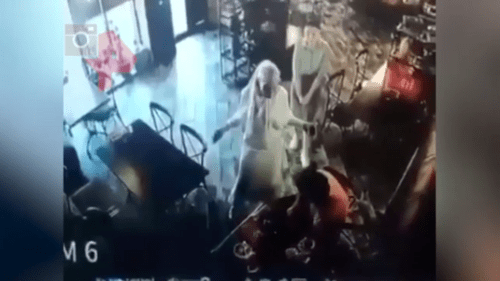 A conflict between Elez Merzhoev (dressed in orange) and Aina Getagazova (dressed in white) in a cafe in Nazran on June 15, 2021. Screenshot of the video https://dni.ru/video/2021/6/17/481045.html A conflict between Elez Merzhoev (dressed in orange) and Aina Getagazova (dressed in white) in a cafe in Nazran on June 15, 2021. Screenshot of the video https://dni.ru/video/2021/6/17/481045.html