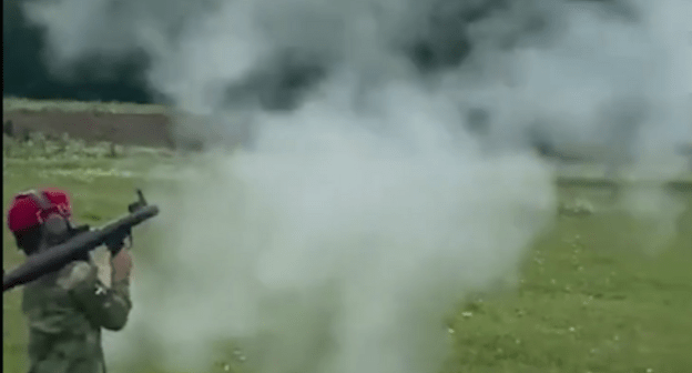A child shooting from a grenade launcher. Screenshot of a video posted at the Lenta.ru website on 01.07.21, https://lenta.ru/news/2021/07/01/grntmt/ A child shooting from a grenade launcher. Screenshot of a video posted at the Lenta.ru website on 01.07.21, https://lenta.ru/news/2021/07/01/grntmt/