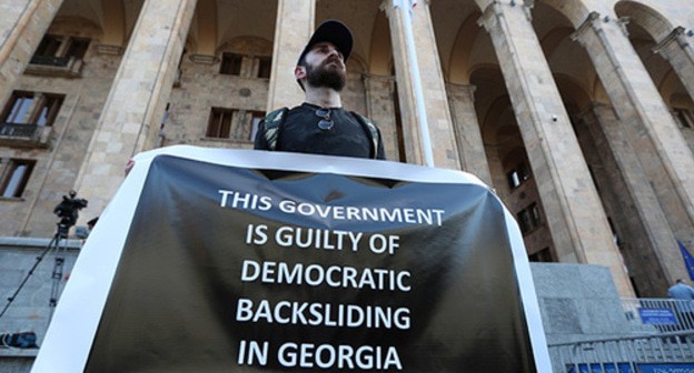 Activist holding a poster at a rally demanding the resignation of the Prime Minister and the government of Georgia, Tbilisi, July 17, 2021. Photo: REUTERS/Irakli Gedenidze Activist holding a poster at a rally demanding the resignation of the Prime Minister and the government of Georgia, Tbilisi, July 17, 2021. Photo: REUTERS/Irakli Gedenidze