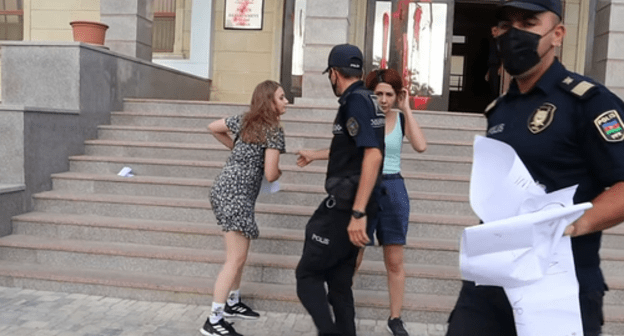 Policemen taking the posters away from the activists, Baku, August 4, 2021. Screenshot: Meydan TV, http://www.youtube.com/watch?v=Sm9Wy_44uWs Policemen taking the posters away from the activists, Baku, August 4, 2021. Screenshot: Meydan TV, http://www.youtube.com/watch?v=Sm9Wy_44uWs